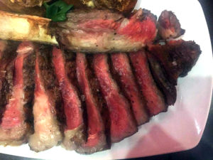 Long-bone ribeye served with gruyere popovers