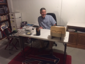 Greg is pictured at the desk where he does most of his preliminary work before sending the objects to us at the museum