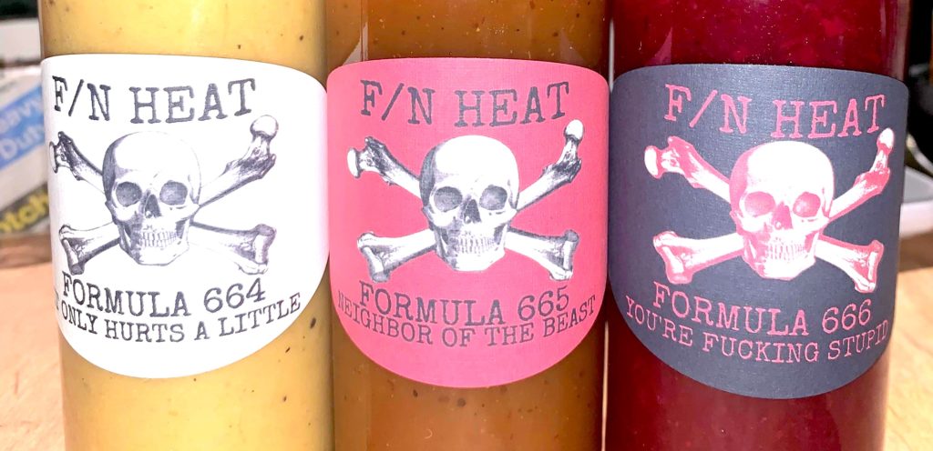 Three different bottles of hot sauce called F/N Heat