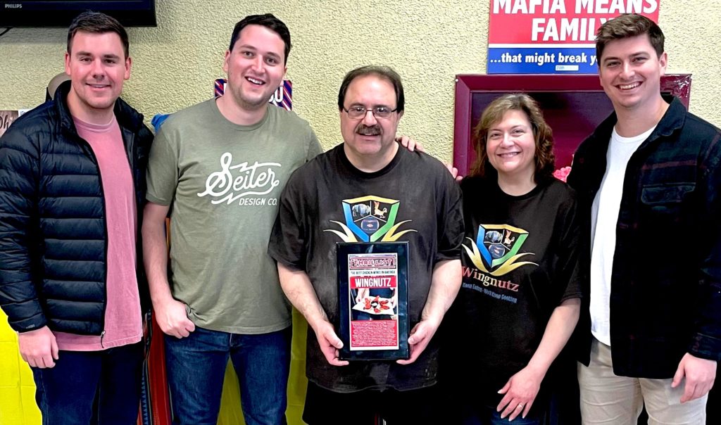 Photo of group standing at lunch holding a plaque at WingNutz
