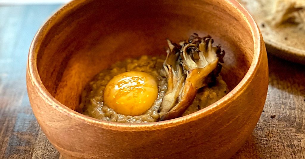 Photo of beautiful mushroom adorned a savory bowl of oats with egg yolk