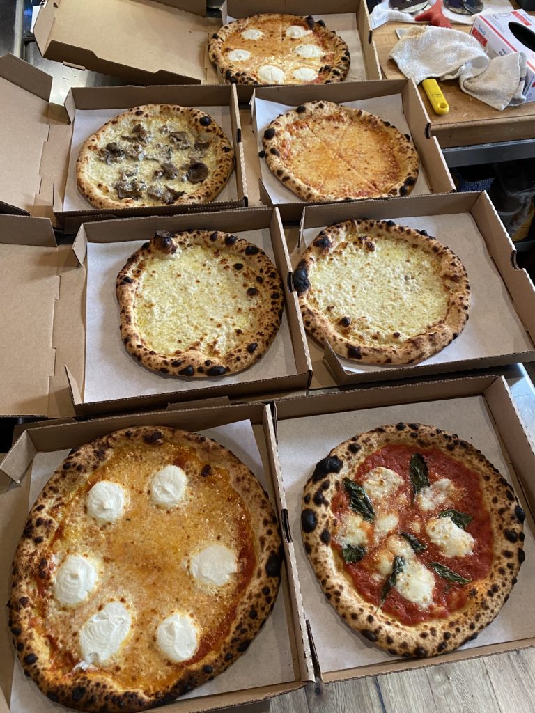 Photos of pizzas in pizza boxes