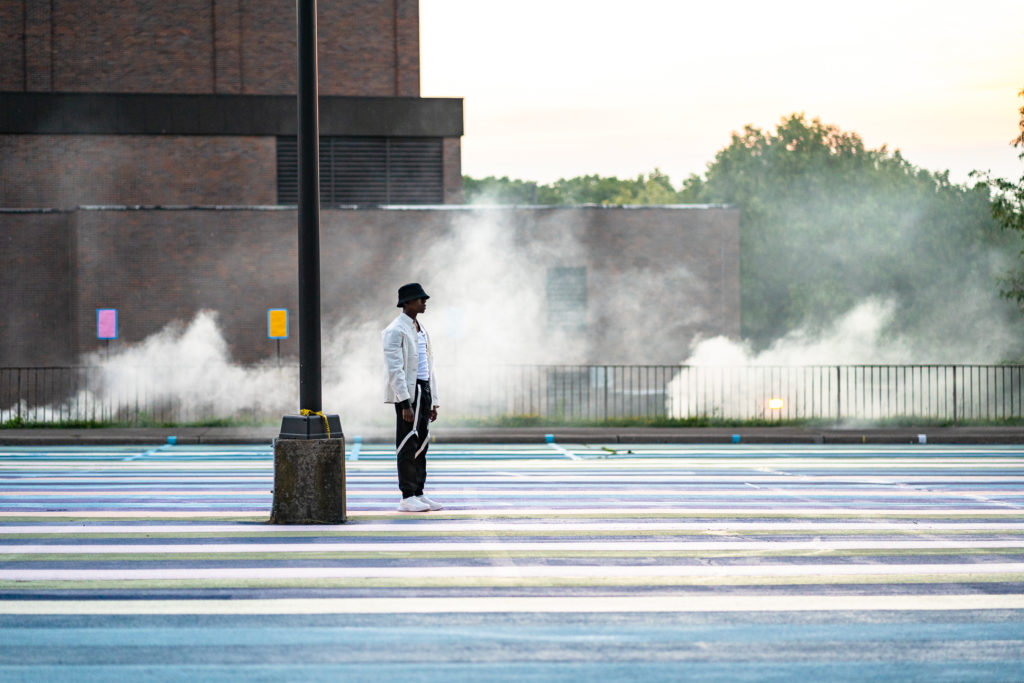 A man stands in the middle of a crosswalk 