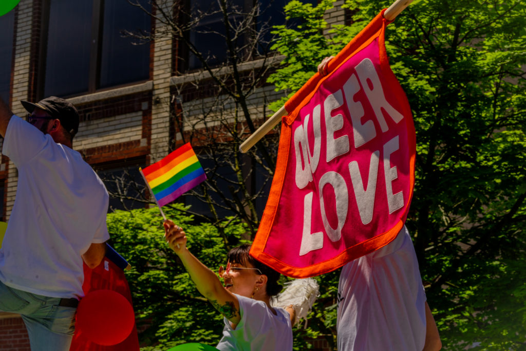 Parade goer waves a queer love flag