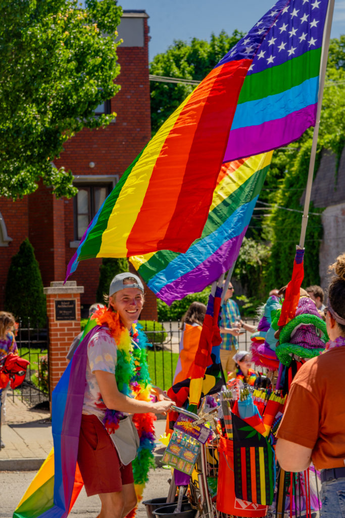A vendor sells pride flags and other accoutrements