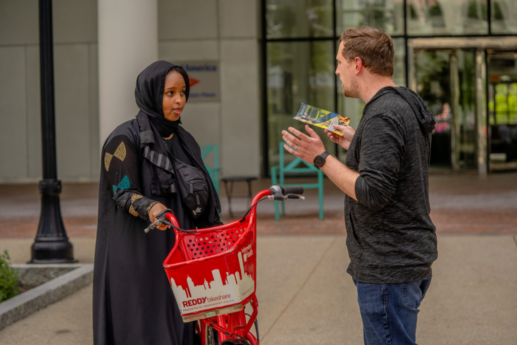 GoBike Buffalo Program Manager Brendan Seney discusses their program with a woman