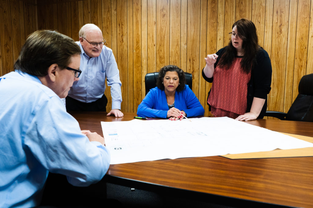 Members of the Main-Ford team review design plans with a customer