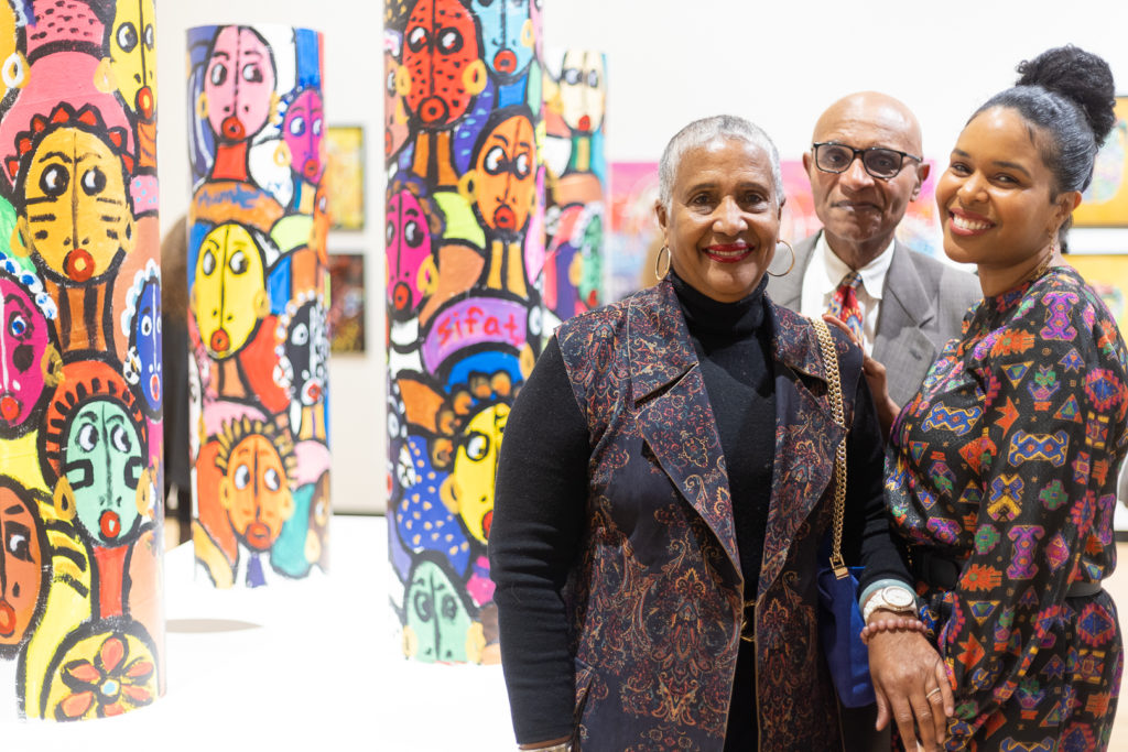 SUNY Trustee Eunice A Lewin, Exhibition Liaison, with her family with artwork created by students from Buffalo Public Schools