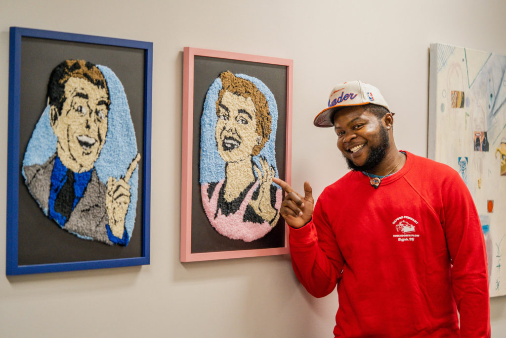 Peter Olonade poses with some of his art