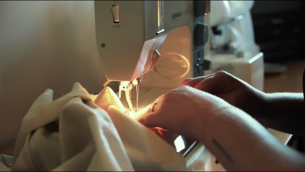 Ashton Warner sews a garment on her sewing machine