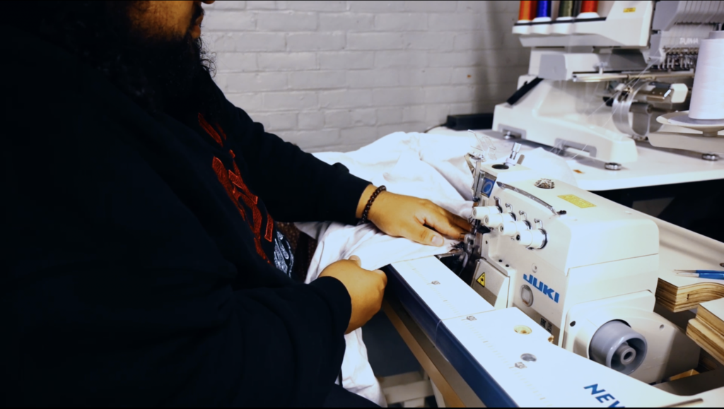 Austin Guyett works on assembling a garment