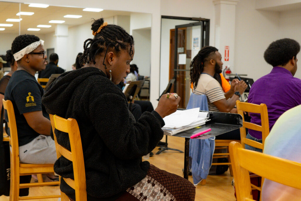 The cast of The Color Purple rehearses with their books