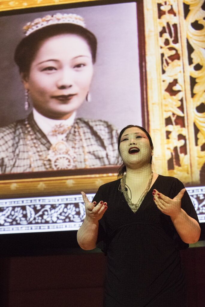 Su Lian Tan speaks in front of an image of her grandmother